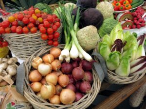 Vegetables, onions, tomatoes, lettuce in baskets at farm stand