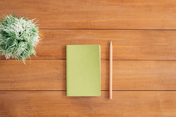 Notebook and pencil on desk.  Write your food shopping story and take charge of your food habits