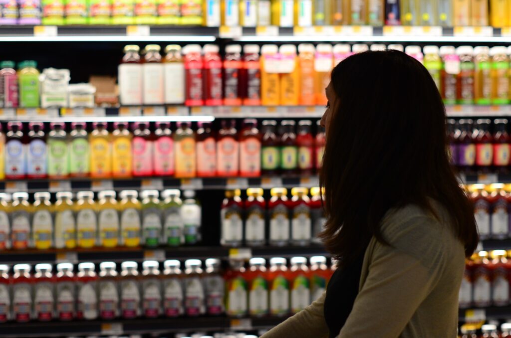 Woman looking at display of bottled drinks